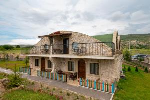 a stone house with a balcony on top of it at Cappadocia Hobbit House in Nevşehir