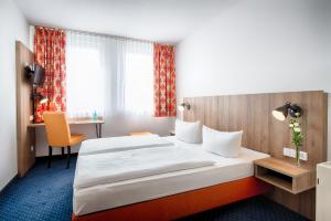 um quarto de hotel com uma cama e uma secretária em ACHAT Hotel Dresden Altstadt em Dresden