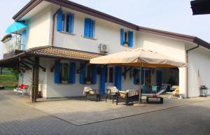 a building with an umbrella and tables and chairs at Villa Roma Holidays in Jesolo