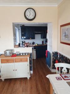 a kitchen with a clock on the wall at Kirkcroft Guest House in Gretna