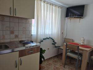 cocina con mesa, mesa pequeña y mesa pequeña en APARTMAN LUKA, en Klenovica