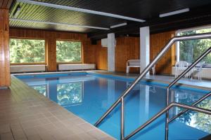 a swimming pool with blue water in a building at Fuchsenstein 44 in Oberkreuzberg