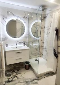 La salle de bains est pourvue d'une douche, d'un lavabo et d'un miroir. dans l'établissement Marseille - Love House Jacuzzi - La Bonne Etoile !, à Marseille