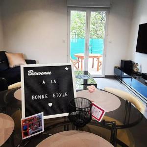 a living room with a table with a sign on it at La Bonne Etoile Marseille ! Hébergement romantique ! Jacuzzi et Piscine chauffée in Marseille