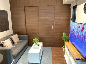 ein Wohnzimmer mit einem Sofa und einem TV in der Unterkunft Air Residences Makati - fully furnished condo with skyline views! in Manila