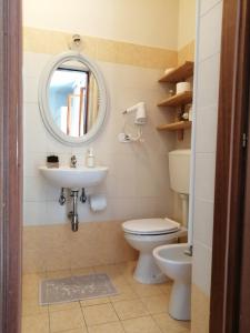 a bathroom with a toilet and a sink and a mirror at Villa Oasi in San Giuliano Terme