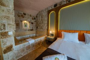 a bedroom with a bed and a bath tub at Cappadocia Hobbit House in Nevşehir