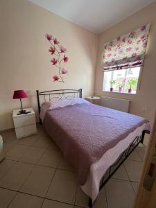 a bedroom with a bed and a flower on the wall at Maria's guesthouse in Batsi