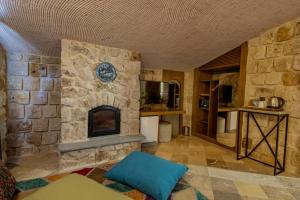 a living room with a stone fireplace in a house at Cappadocia Hobbit House in Nevşehir