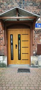a wooden garage door on a brick building at Around the World Vision Apartment - Centrum in Opole