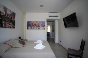 een witte kamer met een bed en een televisie bij Bnbook-Borromeo 4 Fiera Milano Rho in Rho