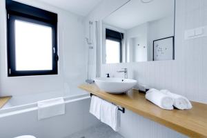 ein weißes Badezimmer mit einem Waschbecken und einem Spiegel in der Unterkunft Plitvice Nest in Rakovica