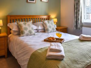 a bed with a tray of bread and a glass of orange juice at The Old Workshop in Keswick