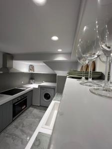 a kitchen with two wine glasses on a counter at Aegean Breeze Minimal Central in Naxos Chora