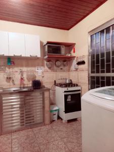 Casa Temporada no Rio de Janeiro في ريو دي جانيرو: مطبخ مع موقد وميكروويف