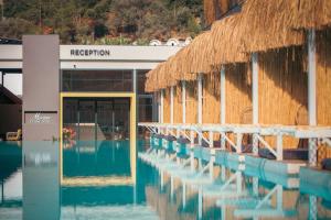 a building with a reflection of a swimming pool at Morina Deluxe Hotel in Oludeniz