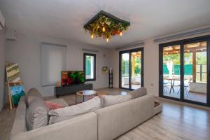 a living room with a couch and a tv at Eroğlu Villas in Fethiye
