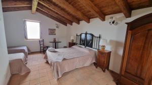 a bedroom with two beds in a room with wooden ceilings at Il Castello di San Sergio in Centola