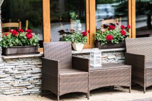 a table and chairs in front of a window with flowers at Pensjonat Zdrojowy in Rabka-Zdrój