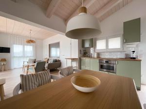 eine Küche und ein Wohnzimmer mit einem Holztisch in der Unterkunft HAUS IM SCHILF 2 - Ferienwohnungen am Hainer See bei Leipzig in Neukieritzsch