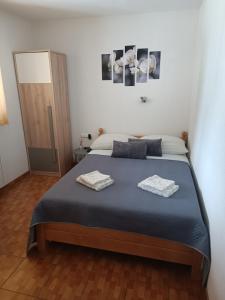1 dormitorio con 1 cama con 2 toallas en Rooms Marijanović Plitvice, en Vrelo Koreničko