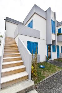 una casa bianca con porte e scale blu di Beach house Quiaios I Figueira da Foz a Quiaios