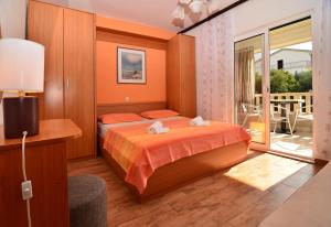 a bedroom with a bed and a balcony at Apartments Mustapic in Makarska