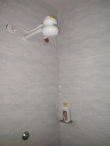 a bathroom with a shower with a light on the wall at Classy Spacious Studio - Waiyaki Way in Rungiri