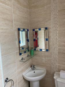 a bathroom with a sink and a mirror at Clonmore Lodge B&B in Quilty