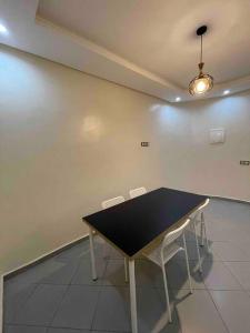 une table noire et deux chaises dans une pièce dans l'établissement Fayb-Sweet-Home-2 - El-Wifaq, à Agadir