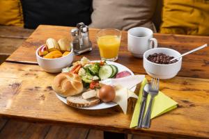 a wooden table with a plate of food on it at Sophie's Hostel in Prague