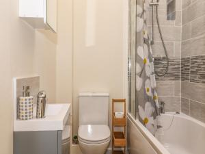 a bathroom with a toilet and a sink and a tub at The Granary in Wigton +28 photos