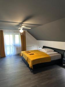 a bedroom with a bed and a ceiling fan at Noclegi Apartamenty Amla 