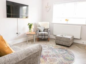 a living room with a couch and a chair at Beaus House in Cheltenham
