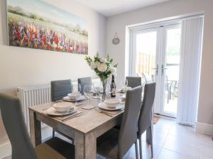 a dining room with a wooden table and chairs at Beaus House in Cheltenham