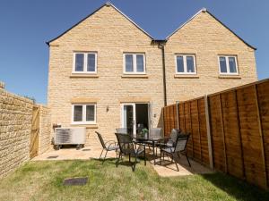 a patio with a table and chairs in front of a house at Beaus House in Cheltenham