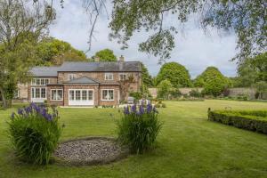 a large brick house with flowers in the yard at The Stable Cottage in Watlington