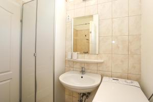 uma casa de banho branca com um lavatório e um espelho em Golden Apartman Balatonlelle em Balatonlelle