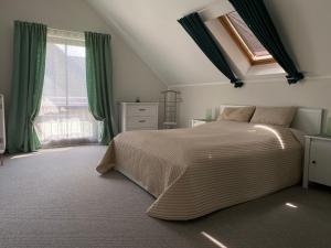 ein Schlafzimmer mit einem großen Bett und einem Fenster in der Unterkunft Ferienhaus Busch in Leipzig
