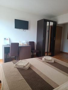 een slaapkamer met een bed en 2 stoelen en een flatscreen-tv bij Rooms Marijanović Plitvice in Vrelo Koreničko