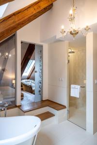 a bathroom with a white tub and a bedroom at Kastiel Palffy in Svätý Jur