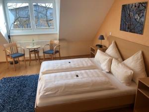 a bedroom with a bed and a table with chairs at Bernsteinsee Hotel in Sassenburg