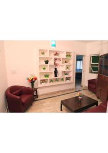 sala de estar con silla roja y mesa en Le Clarisse Guest House, en Pondicherry