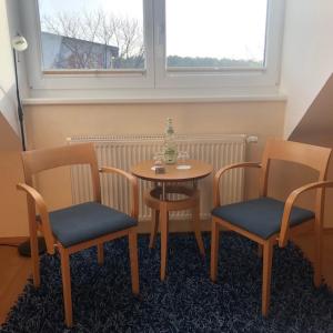 una mesa y dos sillas y una mesa con una botella. en Bernsteinsee Hotel, en Sassenburg