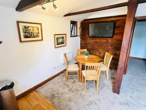 伯青頓的住宿－The Granary，一间带木桌和椅子的用餐室