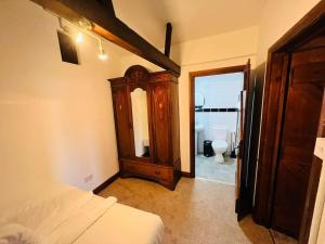 a bedroom with a bed and a dresser and a bathroom at The Granary in Birchington