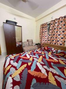 una camera da letto con un letto con un piumone colorato di Your home Away a Sylhet
