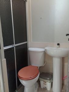 a bathroom with a toilet and a sink at Chalé da Vovó in Soure