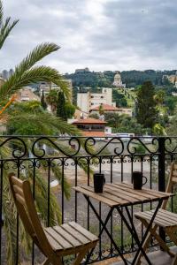 a wooden table and two chairs on a balcony at Via Maria Boutique Suites In The Middle Of The city in Haifa