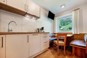 een keuken met witte kasten en een tafel en een raam bij Talblick Apartement 4 in Laion